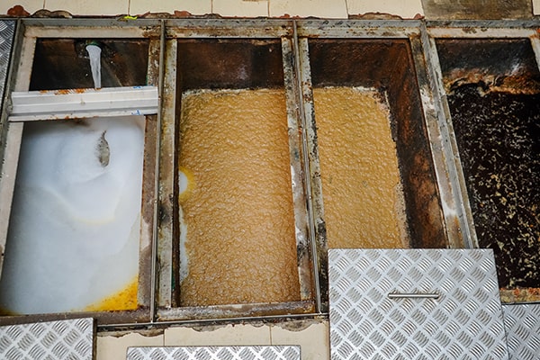 signs that it's time for grease trap maintenance include slow drainage, foul odors, and visible grease buildup